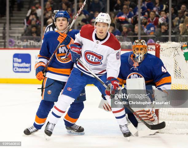 Artturi Lehkonen of the Montreal Canadiens is defended by Sebastian Aho of the New York Islanders as he takes up position in front of Jaroslav Halak...