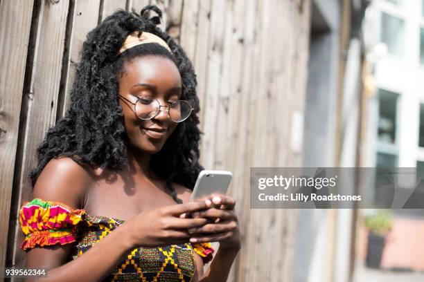 young woman using mobile phone in city - lilly roadstones stock pictures, royalty-free photos & images