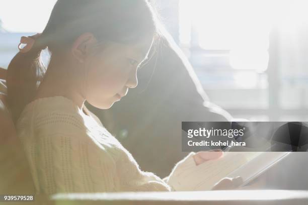 girl reading a book on sofa - love books stock pictures, royalty-free photos & images
