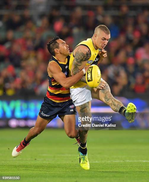 Eddie Betts of the Crows tackles Dustin Martin of the Tigers during the round two AFL match between the Adelaide Crows and the Richmond Tigers at...