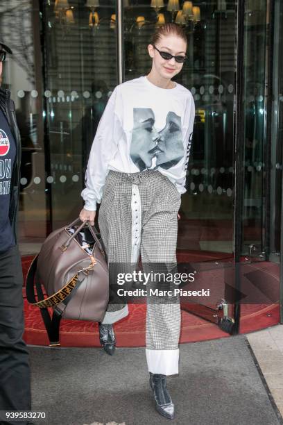 Model Gigi Hadid is seen with a sweater with an image of Cara Delevingne and Adwoa Aboah on March 29, 2018 in Paris, France.