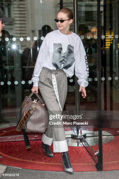 Model Gigi Hadid is seen with a sweater with an image of Cara Delevingne and Adwoa Aboah on March 29, 2018 in Paris, France.