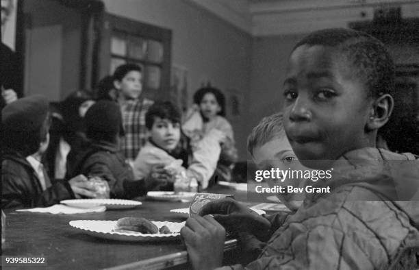 View of a group of boys as they eat during a free breakfast for children program sponsored by the Black Panther Party, New York, New York, winter...