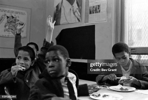 View of several young boys as they raise their hands during a free breakfast for children program sponsored by the Black Panther Party, New York, New...