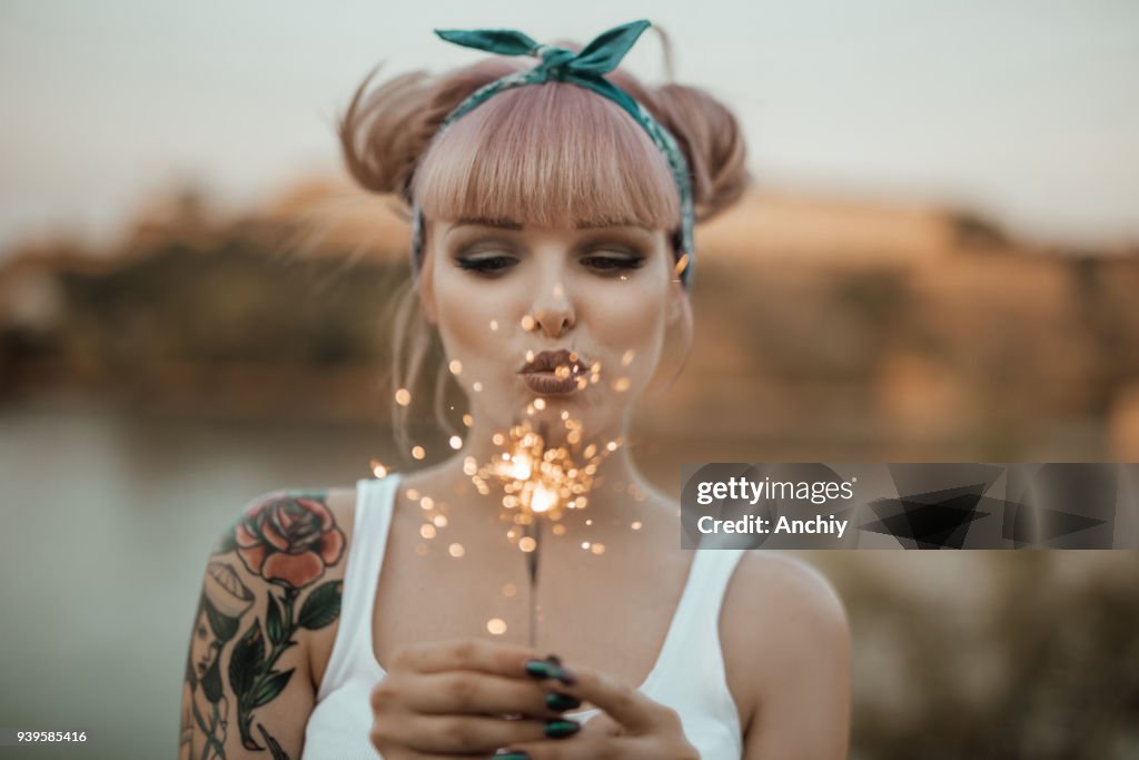 Happy girl holding burning sparklers