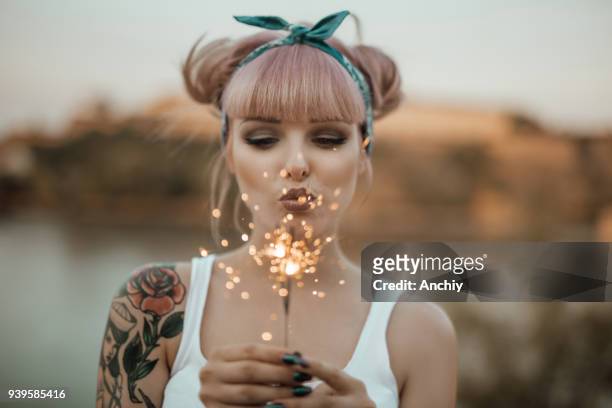 happy girl holding burning sparklers - pin up girl tattoo stock pictures, royalty-free photos & images