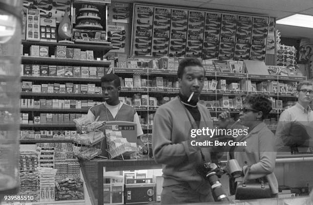 View of clerks and customers in an unidentified store that offers a wide range of cigarettes, as well as other tobacco-related products, candy, and...