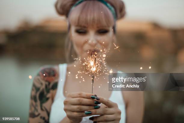 happy girl holding burning sparklers - pin up girl tattoo stock pictures, royalty-free photos & images