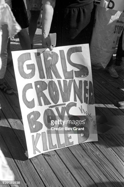 Close-up of a poster that reads 'Girls Crowned, Boys Killed ,' held by a demonstrator on the Atlantic City Boardwalk during a protest against the...