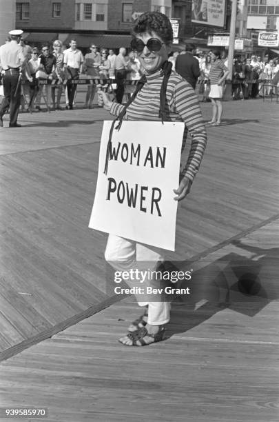 On the Atlantic City Boardwalk, a demonstrator carries a poster that reads 'Woman Power' as she protests the Miss America beauty pageant, Atlantic...