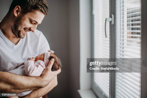 young father with his newborn baby daughter in his arms - baby girls stock pictures, royalty-free photos & images