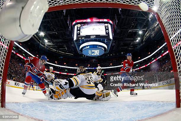 Tim Thomas of the Boston Bruins stops the puck in front of Mike Cammalleri and Andrei Kostitsyn of the Montreal Canadiens during the NHL game on...
