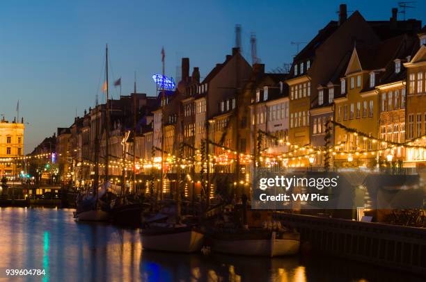 The harbour of Nyhavn at Christmas illuminated at dusk.