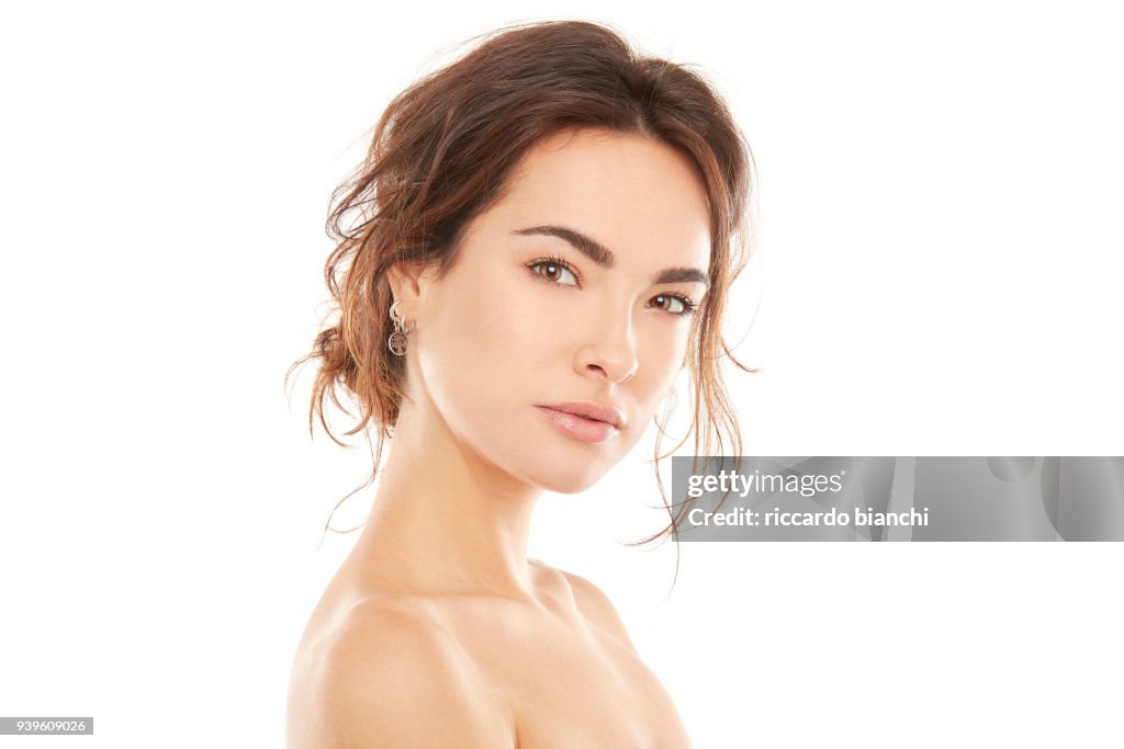 Portrait of beautiful brunette woman with clean face and little smile