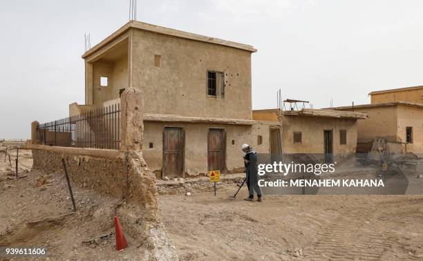 An employee of the HALO Trust, a UK-based non-profit demining organization, uses a metal-detector on-site at Qasr al-Yahud in the occupied West Bank...