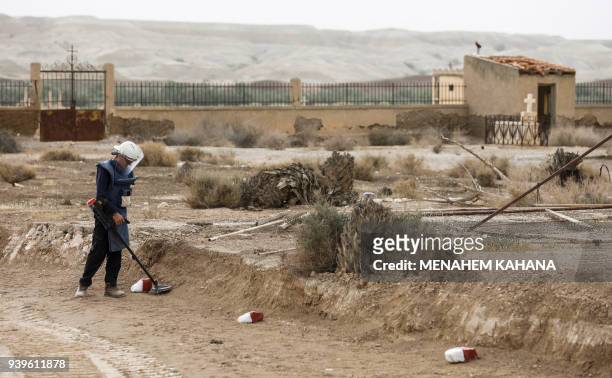 An employee of the HALO Trust, a UK-based non-profit demining organization, uses a metal-detector on-site at Qasr al-Yahud in the occupied West Bank...
