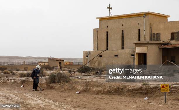 An employee of the HALO Trust, a UK-based non-profit demining organization, uses a metal-detector on-site at Qasr al-Yahud in the occupied West Bank...