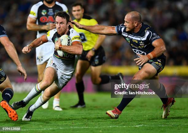 James Maloney of the Panthers looks to get past Matthew Scott of the Cowboys during the round four NRL match between the North Queensland Cowboys and...