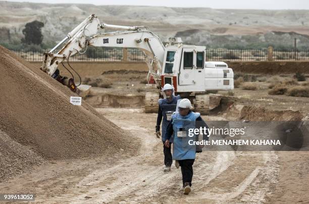 Employees of the HALO Trust, a UK-based non-profit demining organization, walk on-site at Qasr al-Yahud in the occupied West Bank near the Jordan...