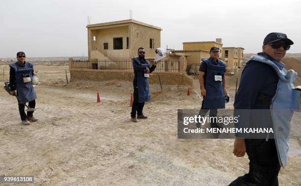 Employees of the HALO Trust, a UK-based non-profit demining organization, walk on-site at Qasr al-Yahud in the occupied West Bank near the Jordan...