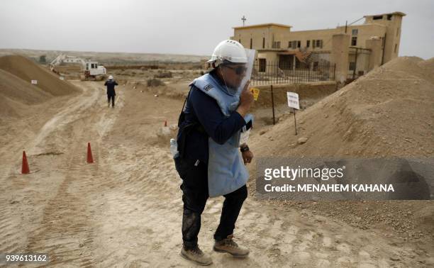 An employee of the HALO Trust, a UK-based non-profit demining organization walks on-site at Qasr al-Yahud in the occupied West Bank near the Jordan...