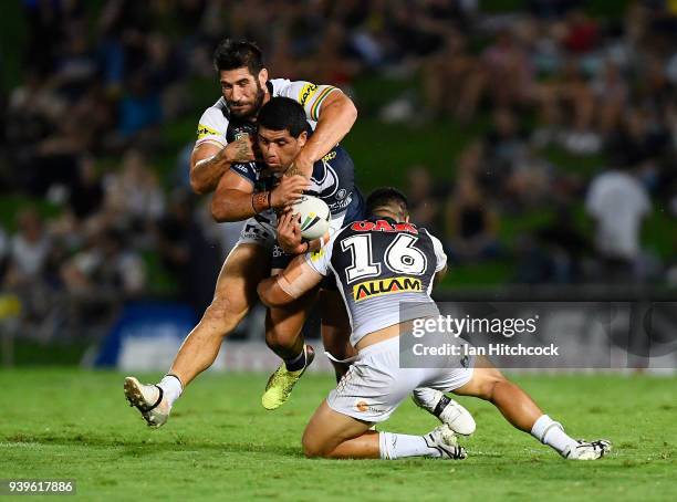 John Asiata of the Cowboys is tackled by Moses Leota and James Tamou of the Panthers during the round four NRL match between the North Queensland...