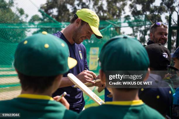 South African cricketer AB de Villiers signs autographs on cricket items for young fans within a team practice session on March 29, 2018 in...