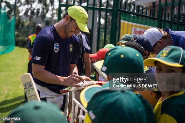 South African cricketer AB de Villiers signs autographs on cricket items for young fans within a team practice session on March 29, 2018 in...