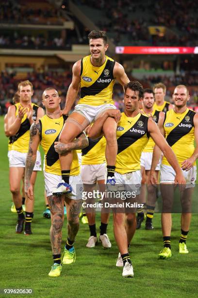 Trent Cotchin of the Tigers is chaired off the field by Dustin Martin of the Tigers and Alex Rance of the Tigers during the round two AFL match...