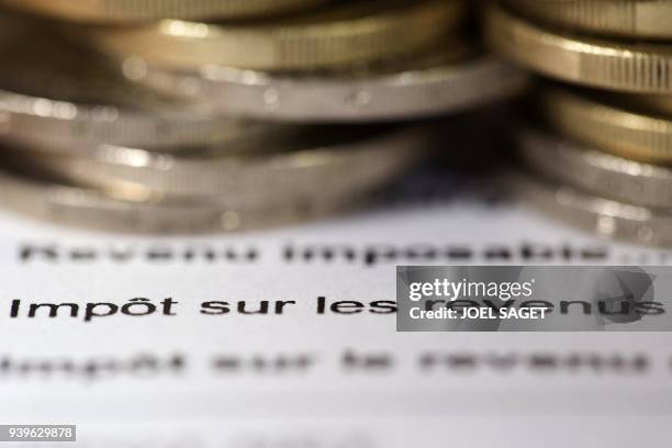 Photo réalisée le 7 septembre 2012 à Paris d'un avis d'imposition sur le revenu et de pièces de 1 euro. La France maintient son objectif de réduire...