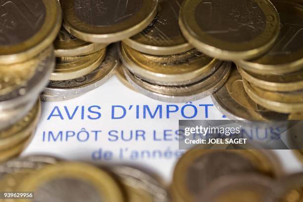Photo réalisée le 7 septembre 2012 à Paris d'un avis d'imposition sur le revenu et de pièces de 1 euro. La France maintient son objectif de réduire...