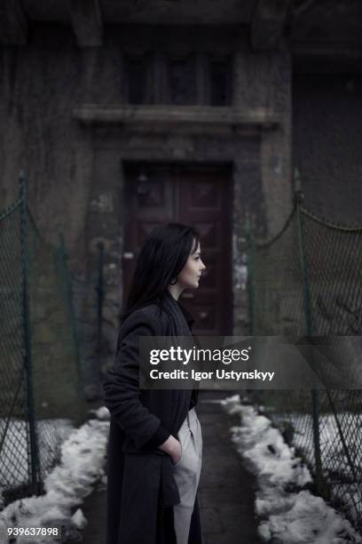 young woman walking on city sidewalk - coat imagens e fotografias de stock