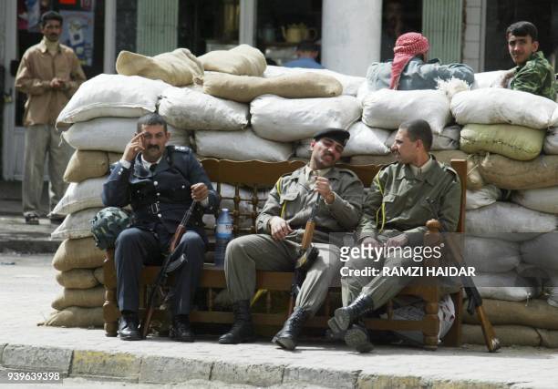 Iraqi militiamen from the ruling Baath party rest in Baghdad 20 March 2003 after the US launched its first attacks on the Iraqi capital. Iraq...