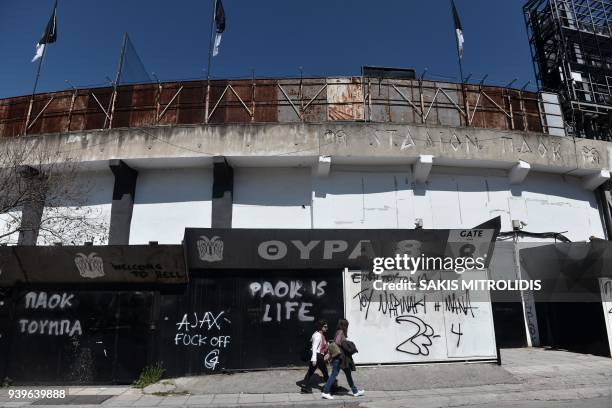 People walking next to Toumba stadium, home of PAOK FC, in Thessaloniki on March 29, 2018. The owner of Greek club PAOK has been banned for three...