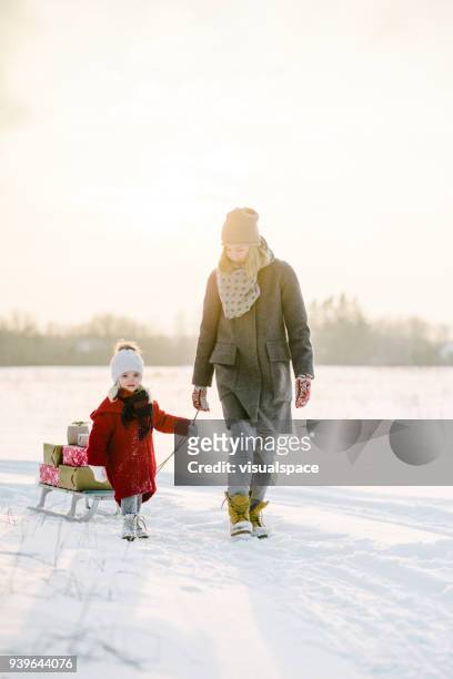 mother and daughter with christmas presents in the sunset - winter still life stock pictures, royalty-free photos & images