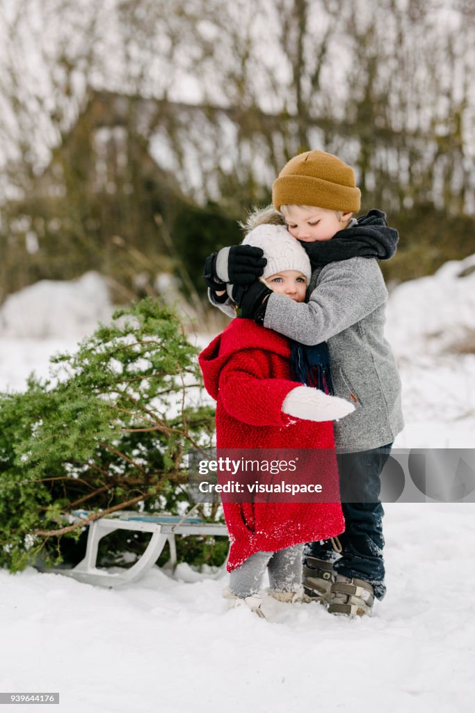 Broer knuffels zus tijdens de kerst