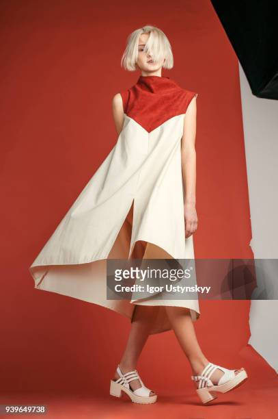 portrait of woman in studio on the red background - woman fashion model in dress stock-fotos und bilder