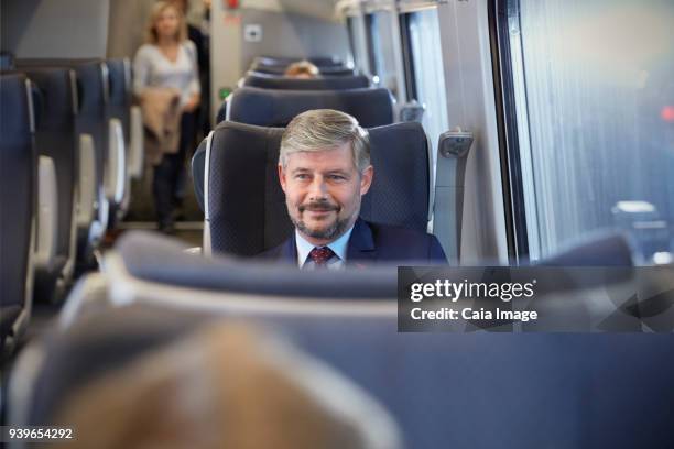 confident businessman on passenger train - train interior stock pictures, royalty-free photos & images