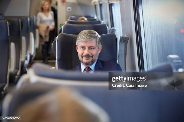 confident businessman on passenger train - tåginteriör bildbanksfoton och bilder