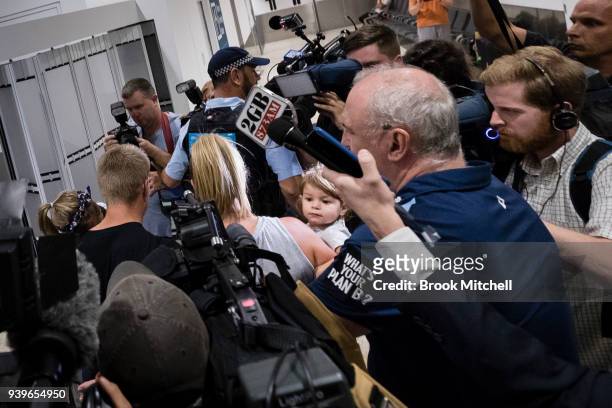Australian Test cricketer David Warner and his young family wade through a massive media pack at Sydney International Airport on March 29, 2018 in...