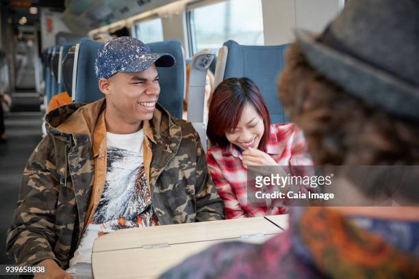 young couple laughing on passenger train - tåginteriör bildbanksfoton och bilder