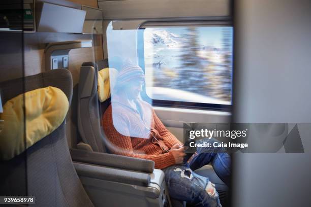 young man using smart phone on passenger train - luxury train interior stock pictures, royalty-free photos & images