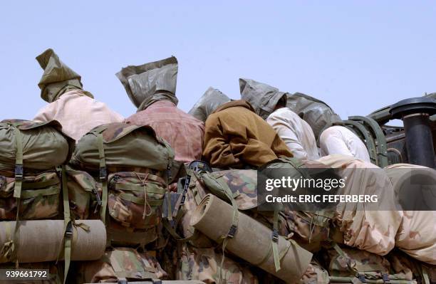 Iraqi prisoners with plastic bags on their heads are taken away in a truck to the south of Iraq, after beeing arrested by the American forces near...