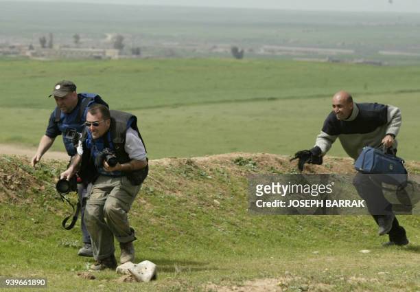 Three journalists from left to right: David Pratt from the Sunday Herald, Patrick Barth, of Getty Images, and Faris Rashid a Kurdish assistant, run...