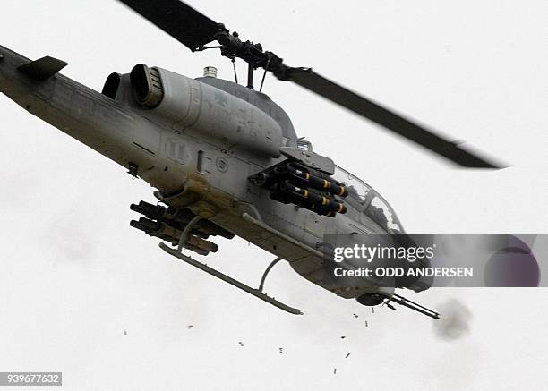 Shell casing drops to the ground as a US AH-1W Super Cobra helicopter fires on positions in the strategic southern port of Umm Qasr 22 March 2003. US...