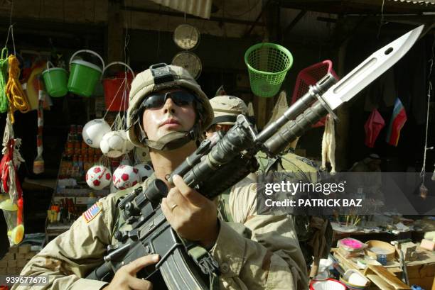 Soldier from the 82nd Airborne division stands on guard in a commercial street in Fallujah, during a search for a weapons cache in the area, 50 kms...