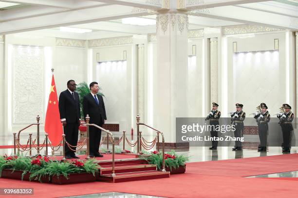 Chinese President Xi Jinping and Namibia's President Hage G. Geingob listen to their national anthems during a welcoming ceremony inside the Great...