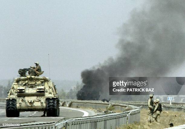 Smoke billows from a US Bradley fighting vehicle following at attcak on the highway overlooking the restive town of Fallujah, 50km west of Baghdad,...