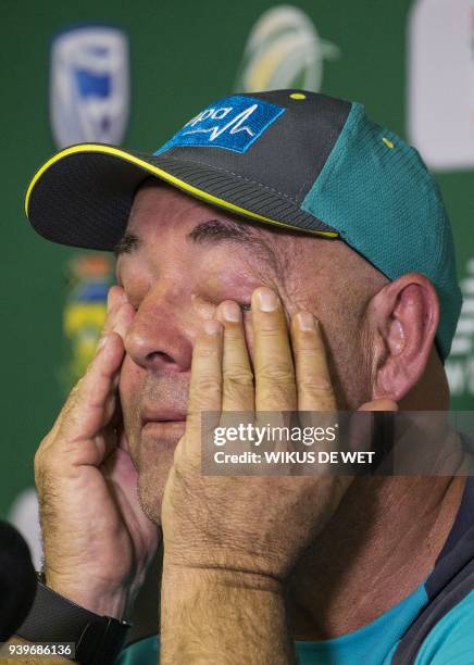 Head Coach of the Australia cricket team Darren Lehmann wipes his eyes as he responds to questions during a press conference in Johannesburg on March...