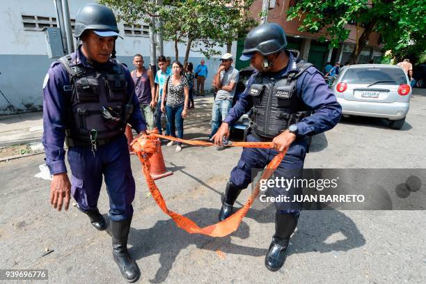 Police agents guard headquarters after a fire engulfed police holding cells while relatives of prisoners wait outside, in Valencia, northern Carabobo...